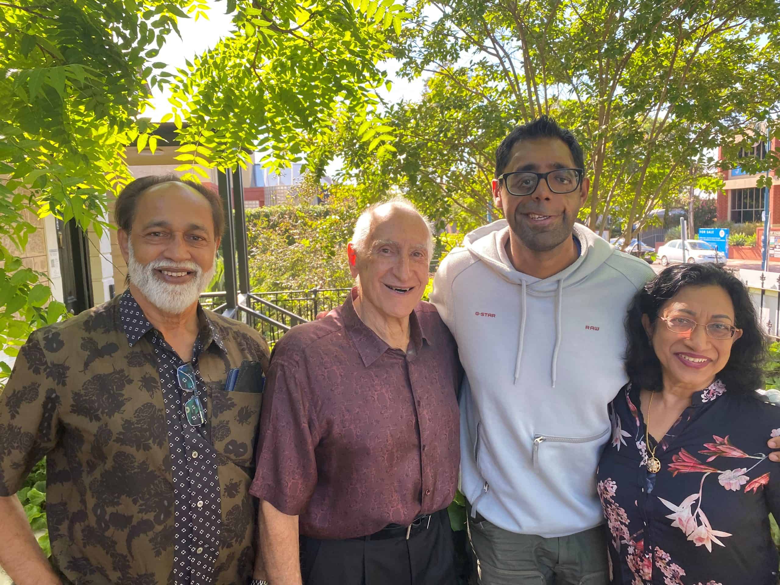 Man who was born with a complex craniofacial cleft standing outside the Craniofacial Australia office with his parents and Prof David