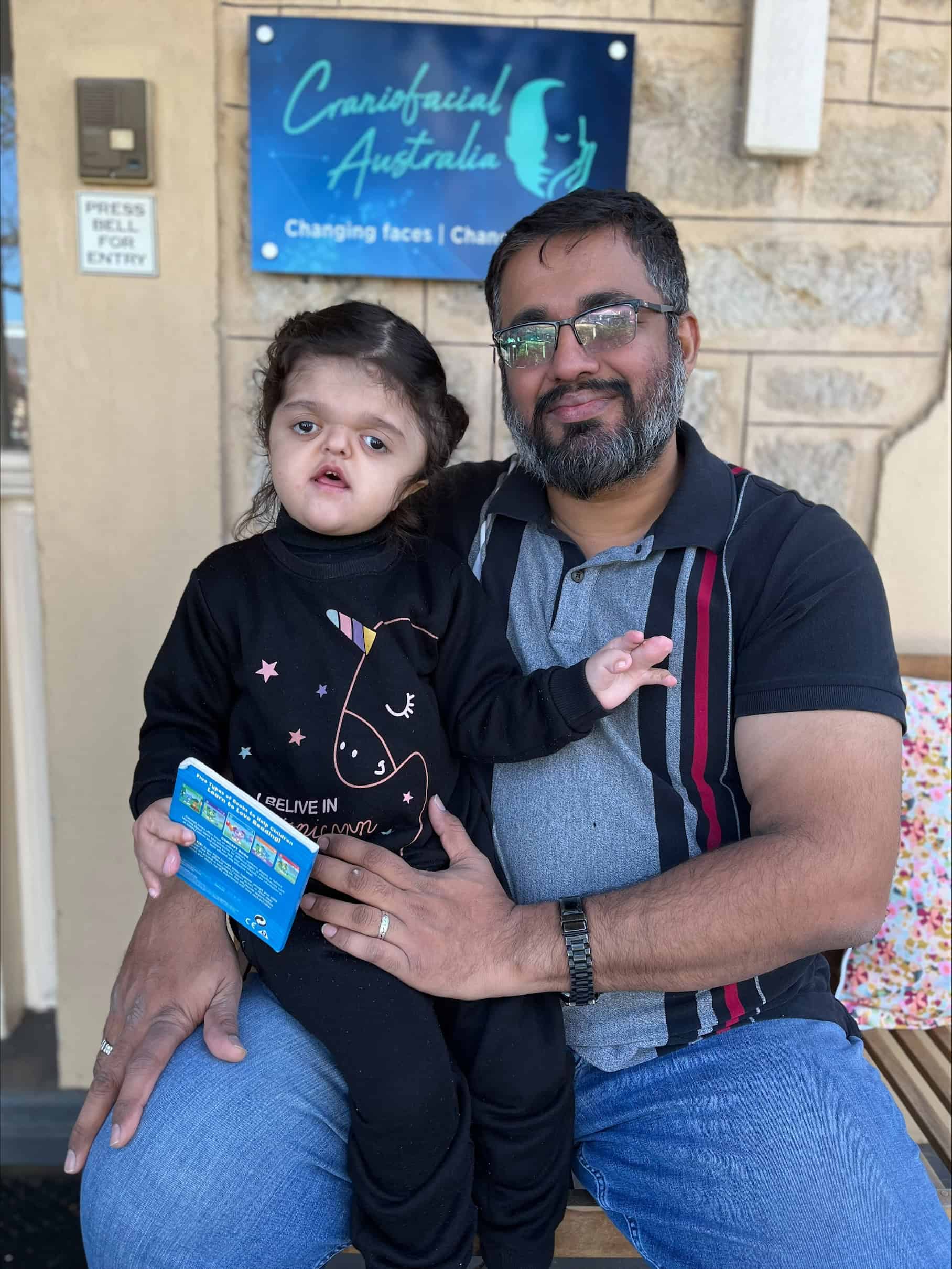 Little girl with Apert syndrome with her father