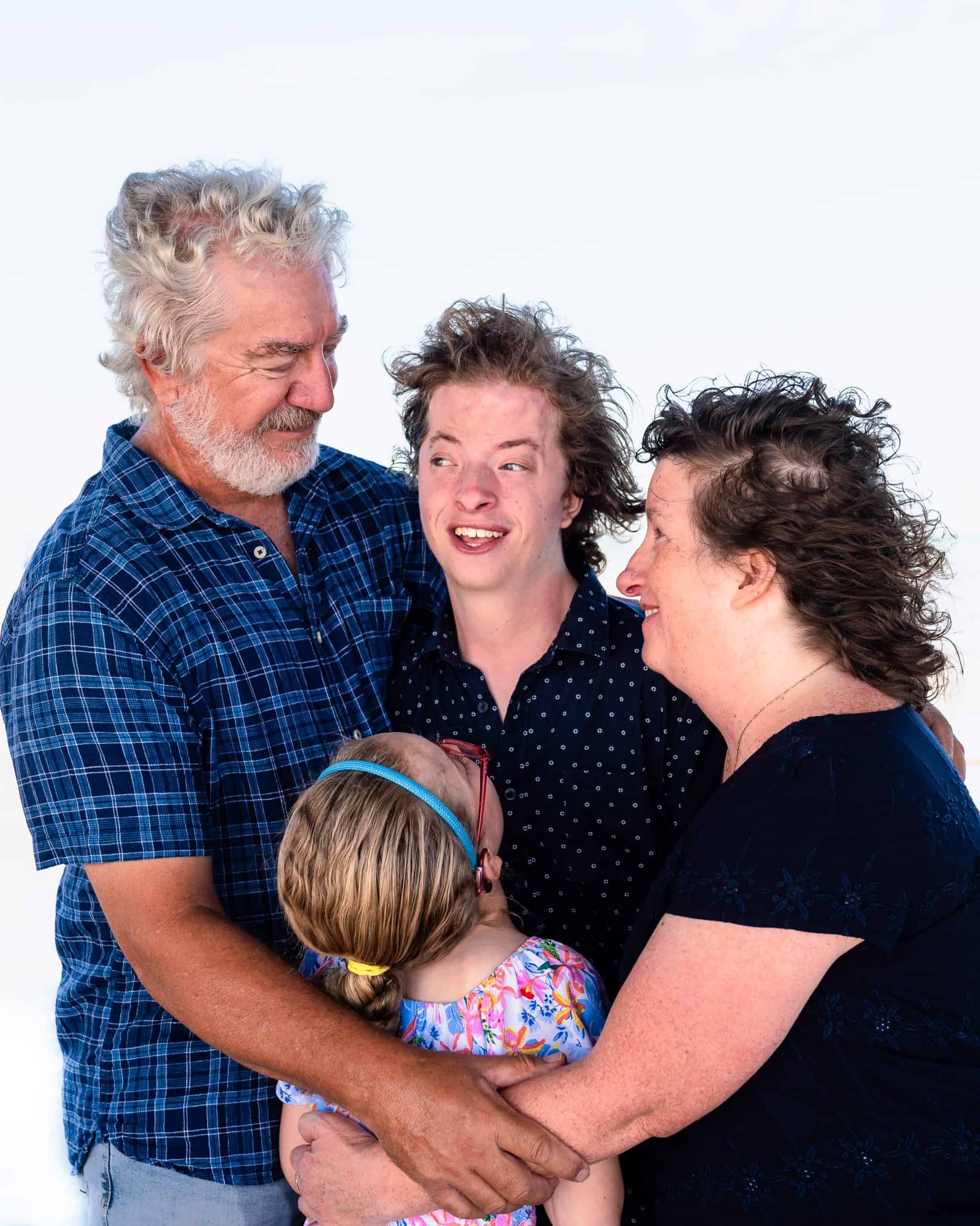 Family of young man with bicoronal synostosis, embracing