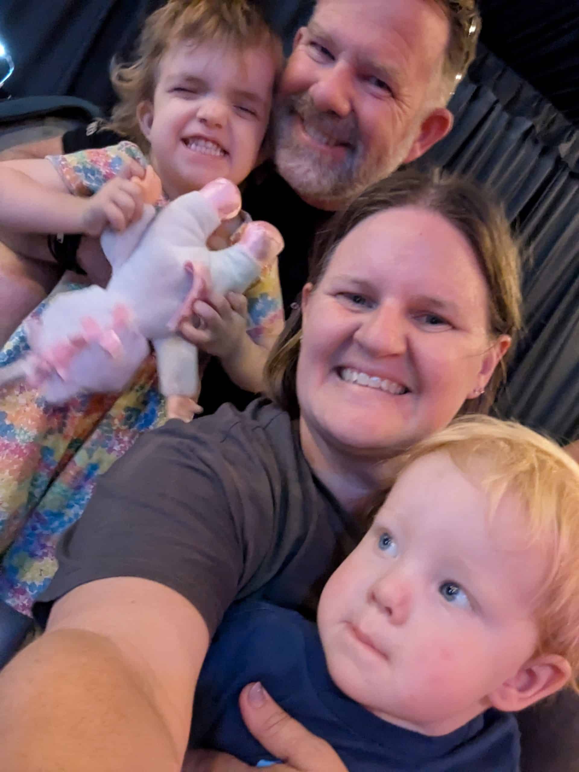 Little girl with Noonan syndrome and sagittal synostosis surrounded by her family
