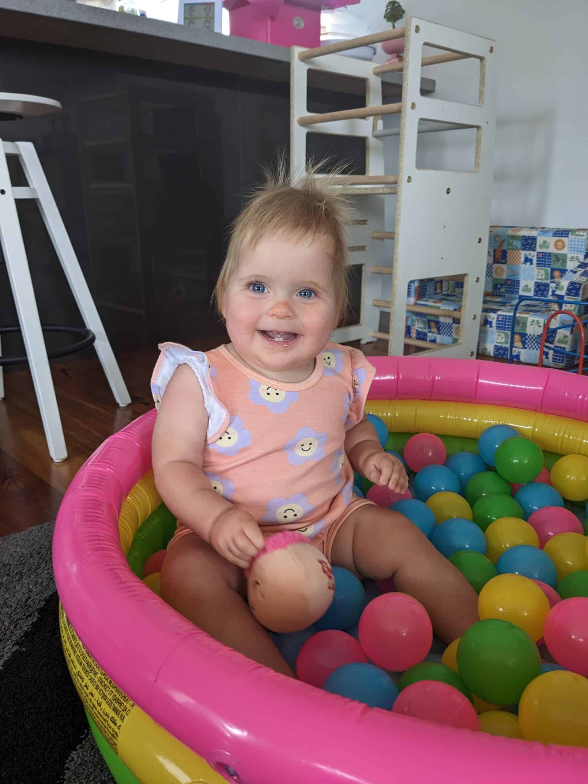 Little girl with sagittal synostosis before surgery sitting in a ball pit