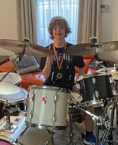 Boy with bicoronal synostosis, playing a drum set