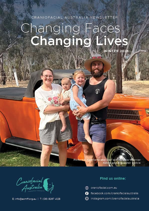 A colourful family photo outdoors featuring a man, woman, and two children, with a vintage orange ca.