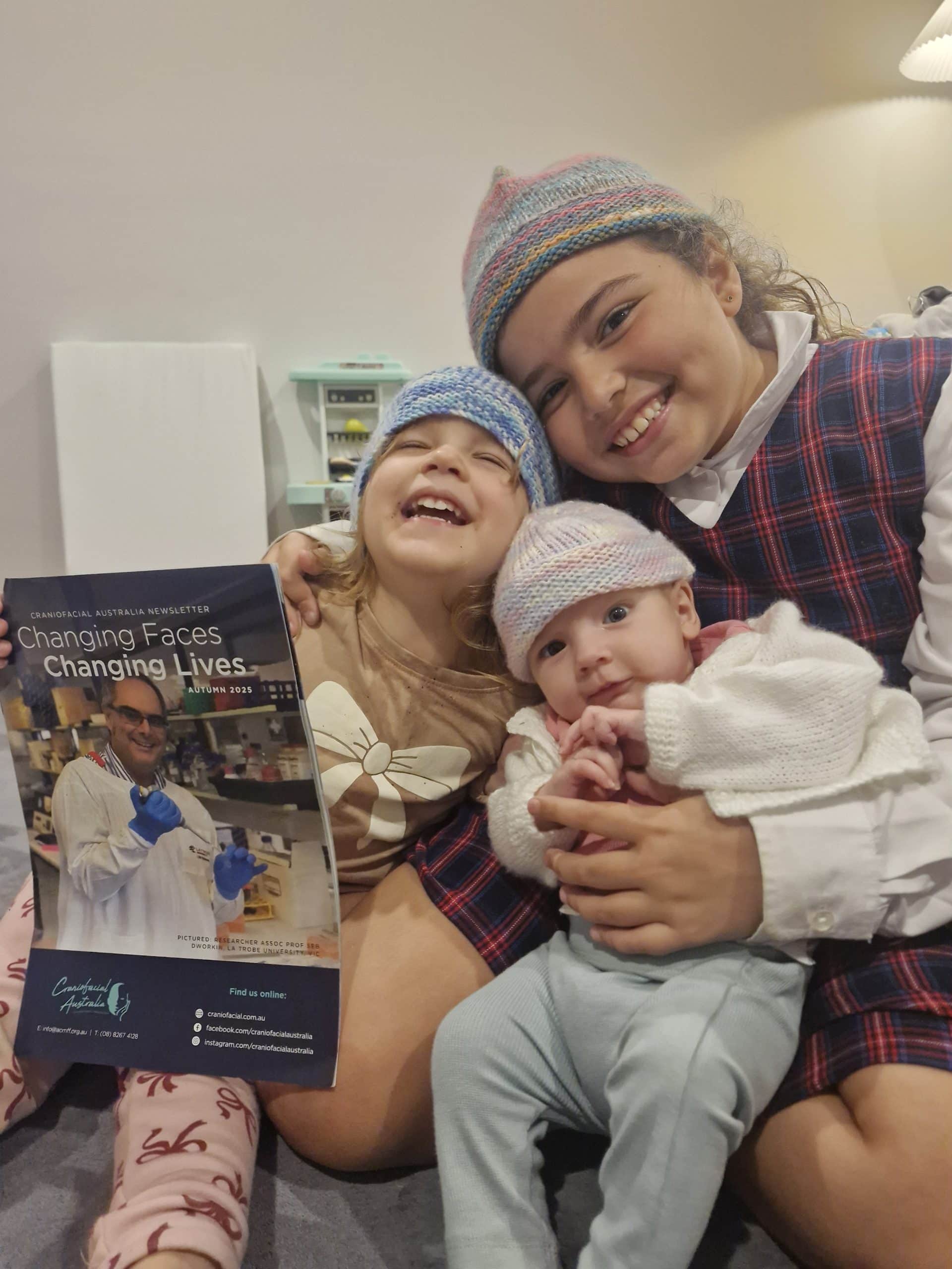 Happy children with craniofacial condition and caregiver in clinic setting.