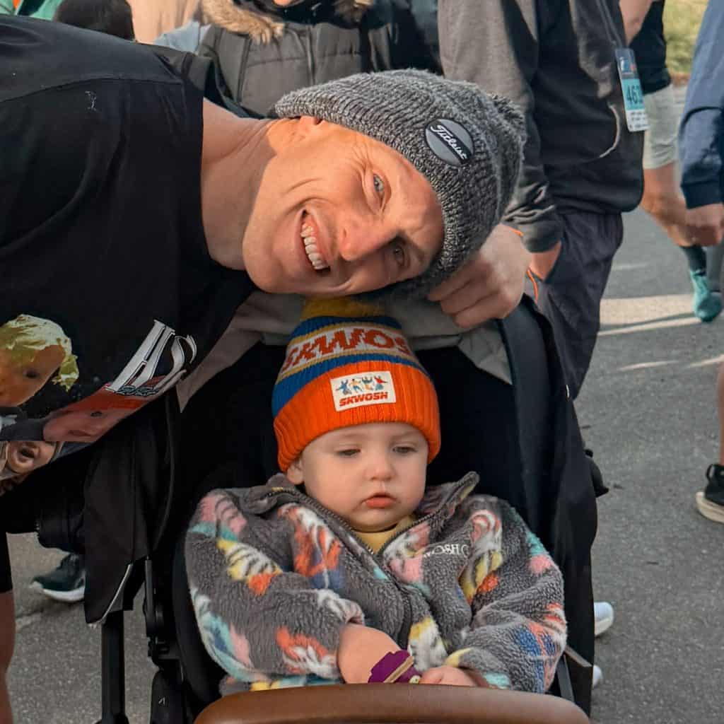 Harvey Greenway smiling with a young child in a stroller at a public event in Australia.